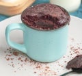 Chocolate biscuit cake in a blue ceramic mug, microwave baking. muffin