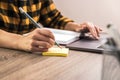 Quick note. close up hands of a businesswoman, student or freelancer in yellow shirt making a note on sticky note Royalty Free Stock Photo