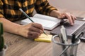 Quick note. close up hands of a businesswoman, student or freelancer in yellow shirt making a note on sticky note Royalty Free Stock Photo