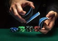 Quick shuffling of playing cards by the hands of an experienced dealer or croupier in a poker club on a green table with playing Royalty Free Stock Photo