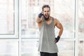 Quickly! Angry young adult muscular trainer man with curly long hair standing, pointing finger to you and blame, holding hand on Royalty Free Stock Photo