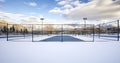 The Quiet Beauty of a Tennis Court Blanketed in Snow, with Distant Homes and Mountains Under a Cloud-Filled Sky Royalty Free Stock Photo
