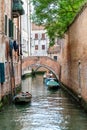 Quiet Canal in Venice with Arching Bridge and Boats Royalty Free Stock Photo