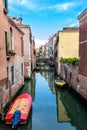 Quiet Canal in Venice with wooden Bridge and Boats Royalty Free Stock Photo