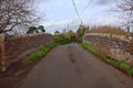 Quiet country lane on a hump back bridge over the Taunton and Bridgewater canal in Somerset on an overcast autumn day