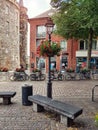 Aachen, Germany - July 31, 2022: Quiet cozy street, with a lamppost decorated with red flowers against