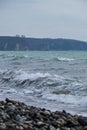 The ocean is blue and turquoise and waves with sea foam. Quiet and exciting black Sea and rock and forest in background. Nature of