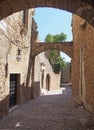 Quiet medieval cobbled street in rhodes town with old buildings and arches between stone buildings Royalty Free Stock Photo