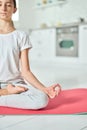 Quiet mind. Cropped shot of relaxed hispanic teenage girl in sportswear practicing yoga, meditating on a mat in the