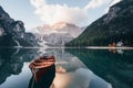 Quiet nice day. Wooden boat on the crystal lake with majestic mountain behind. Reflection in the water. Chapel is on the Royalty Free Stock Photo