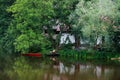 Quiet Place On The Water With A Red Boat, Cottage And Trees In