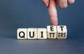 Quiet quitters symbol. Concept words Quiet quitters on wooden cubes. Businessman hand. Beautiful grey table grey background.