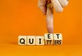 Quiet quitters symbol. Concept words Quiet quitters on wooden cubes. Businessman hand. Beautiful orange table orange background.