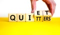 Quiet quitters symbol. Concept words Quiet quitters on wooden cubes. Businessman hand. Beautiful yellow table white background.