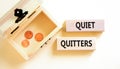 Quiet quitters symbol. Concept words Quiet quitters on wooden blocks. Beautiful white table white background. Wooden chest with