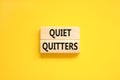 Quiet quitters symbol. Concept words Quiet quitters on wooden blocks. Beautiful yellow table yellow background. Business and quiet