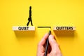 Quiet quitters symbol. Concept words Quiet quitters on wooden blocks. Beautiful yellow table yellow background. Businessman hand.