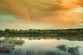 quiet river or lake in the sunset light with rainbow. Fishing and natural attractions