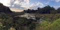 Quiet rustic panoramic landscape with river, church and clouds on the sky in sunset Royalty Free Stock Photo