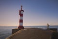 Young man enjoys the sunrise on the pier fishing in the ocean waters Royalty Free Stock Photo