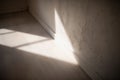 Sunlit empty room corner with textured wall and soft dramatic floor shadows Royalty Free Stock Photo