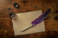 A quill pen with a vintage ink well and old parchment paper Royalty Free Stock Photo