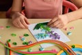 Quilling technique. Girl making decorations or greeting card. Paper strips, flower, scissors. Handmade crafts on holiday: Birthday Royalty Free Stock Photo