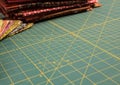 Quilt rotary cutting mat with multicolored fabric in background