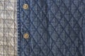 Quilted fabric denim cloth element texture close up with metal buttons Royalty Free Stock Photo