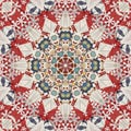 Kaleidoscopic starburst pattern of vintage quilt fabric, predominately red Royalty Free Stock Photo