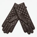 Quilted leather gloves in dark brown, featuring a diamond pattern. The gloves are Royalty Free Stock Photo