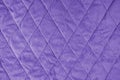 Quilted purple velours fabric background, wrinkled soft blanket surface Royalty Free Stock Photo