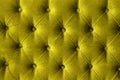 Quilted velour buttoned Illuminating yellow color fabric wall pattern background. Elegant vintage luxury bright golden mustard