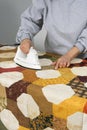 Quilter ironing a bow tie quilt top