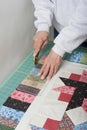 Quilter trimming piano keys of quilt top fabric.