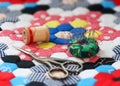 Quilting supplies on a colorful hexagon patterned quilt