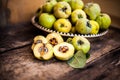 Quince fruits on a wooden background. Harvest of autumn fruits. Yellow tart hard fruit. Cut apple-quince with leaf