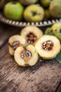 Quince fruits on a wooden background. Harvest of autumn fruits. Yellow tart hard fruit. Cut quince with leaf. Terry