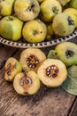 Quince fruits on a wooden background. Harvest of autumn fruits. Yellow tart hard fruit. Cut quince with leaf. Terry