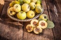 Quince fruits on a wooden background. Harvest of autumn fruits. Yellow tart hard fruit. Cut quince with leaf. Terry