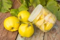 Quince, glass jar with candied quince on wooden background