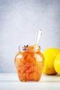 Quince jam or confiture in glass jar with cinnamon and anise on gray kitchen table background, copy space