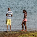 Unidentified local couple look at the water on the coast of the