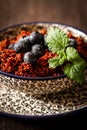 Quinoa blueberries and raspberries on a plate with black backgro Royalty Free Stock Photo