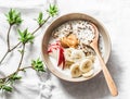 Quinoa, coconut milk, banana, apple, peanut butter porridge on light background, top view. Delicious diet, vegetarian breakfast or