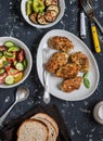 Quinoa crusted chicken, vegetable salad, grilled eggplant and pepper - dinner table. On a dark background Royalty Free Stock Photo