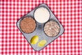 Quinoa and lemon on a redVegetable food. Close-up of a decorative plate with three bowls with buckwheat, rice, quinoa and lemon on