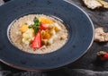 Quinoa porridge with fruits, strawberries, pear, banana and coconut milk in plate over grey background. Healthy breakfast Royalty Free Stock Photo