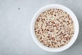 Quinoa. Red white brown quinoa seeds in bowl. Mixed organic raw quinoa seeds on gray stone background Royalty Free Stock Photo