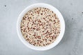 Quinoa. Red white brown quinoa seeds in bowl. Mixed organic raw quinoa seeds on gray stone background Royalty Free Stock Photo